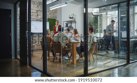 Office Conference Room Meeting: Female Chief Executive Talking to a Diverse Team of Professional Businesspeople. Creative People Listen to CEO Discuss Design, Data Analysis, Plan Marketing Strategy