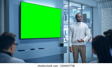 Office Conference Room Meeting Presentation: Charismatic Black Businessman Talks, Uses Green Screen Chroma Key Wall TV. Successfully Presenting A E-Commerce Product To Group Of Multi-Ethnic Investors