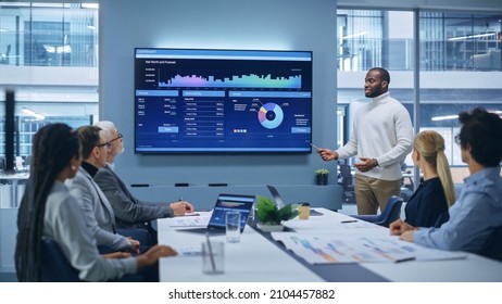 Office Conference Room Meeting Presentation: Black Businessman Talks, Uses TV Screen To Show Company Growth With Big Data Analysis, Graphs, Charts, Infographics. E-Commerce E-Business.