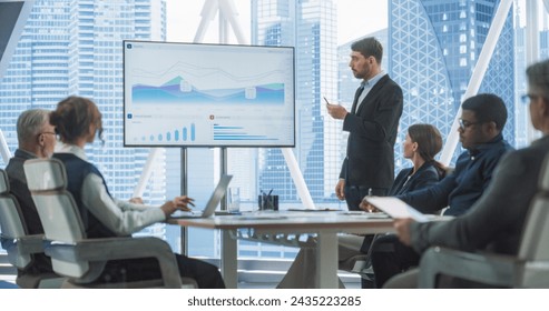 Office Conference Room Meeting Presentation: Caucasian CEO Talks, Uses TV to Show Company Growth with Big Data Analysis, Graphs, Charts, Infographics. Multi-Ethnic e-Commerce Startup Workers. - Powered by Shutterstock