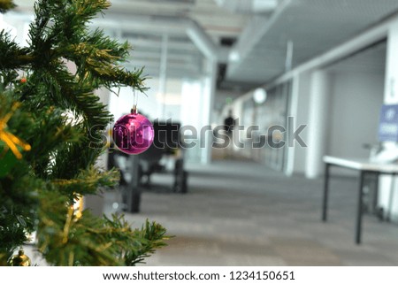 The office is decorated by a Christmas tree with colorful ornaments 
