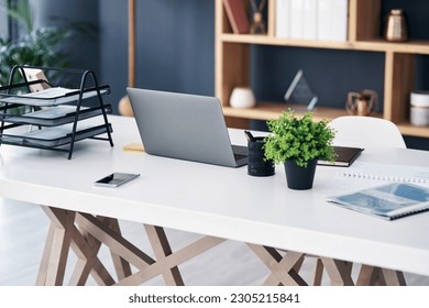 Office desk, business workspace and laptop with professional setup at digital marketing startup. Workstation, paperwork and notebook with work supplies, technology and pc on table in empty workplace