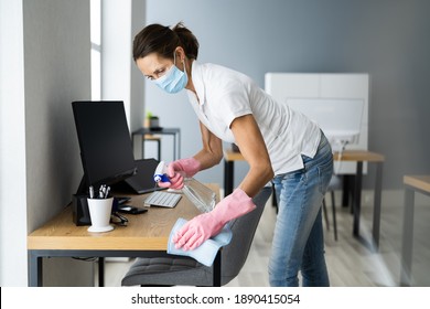 Office Desk Cleaning Service. Professional Janitor In Face Mask