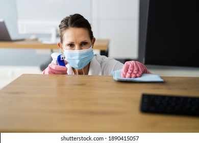 Office Desk Cleaning Service. Professional Janitor In Face Mask