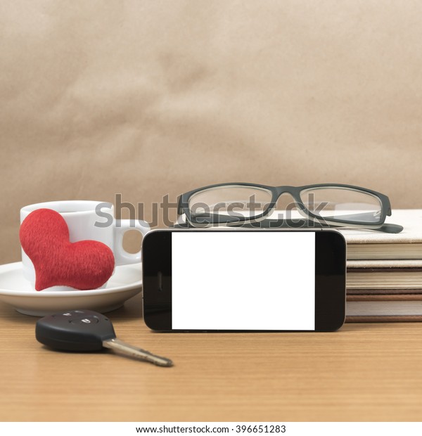 office desk : coffee and phone with car\
key,eyeglasses,stack of\
book,heart