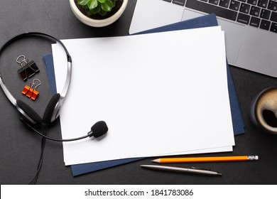 Office desk with headset and laptop. Remote office and work from home concept. Top veiw flat lay with blank paper for copy space - Powered by Shutterstock