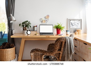 Office Desk With Laptop In Cozy Interior In Scandinavian Style With White Wall With Copy Space, Home Office During Coronavirus. Empty Screen With Mock Up. Workspace And Stylish Design.