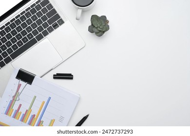 Office desk with laptop, financial reports and coffee cup. Top view with copy space - Powered by Shutterstock