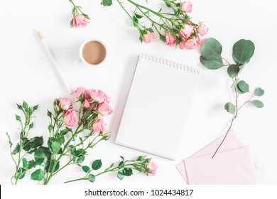 Office desk with notebook, rose flowers, eucalyptus branch, pink paper blank. Flat lay, top view, copy space. - Powered by Shutterstock