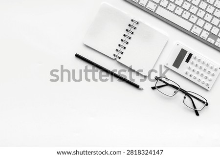 Office desk in order. Geometry. Computer keyboard and office supplies, glasses on white background top view.