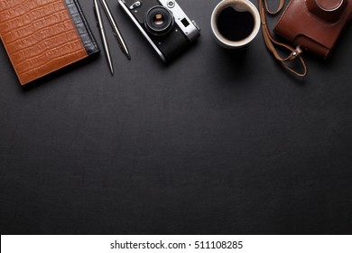 Office Desk With Photo Camera, Coffee And Notepad. Top View With Copy Space