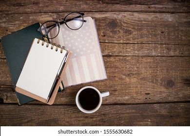 Office Desk Table With Coffee Cup, American History Book, Pen, Notebook And Eyeglasses. Educations, Resolutions, Goal, Plan, Strategy, Politics, International Relations, Economics Concept
