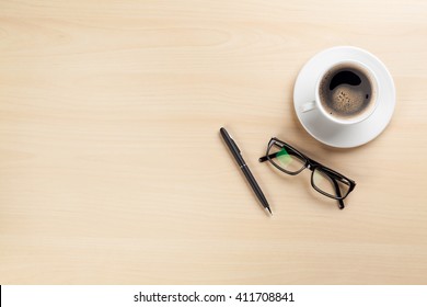 Office Desk Table With Coffee Cup, Pen And Glasses. Top View With Copy Space