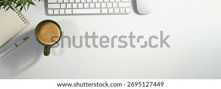Office desk table with computer, cup of coffee and supplies. Top view with copy space panorama, flat lay.