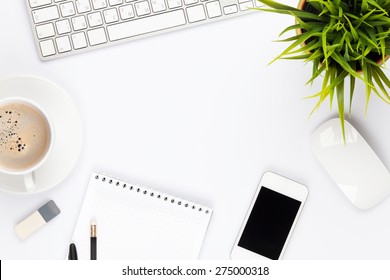 Office desk table with computer, supplies, flower and coffee cup. Top view with copy space  - Shutterstock ID 275000318