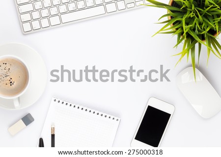 Office desk table with computer, supplies, flower and coffee cup. Top view with copy space 