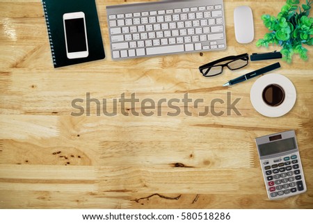 Office desk table with computer, supplies,analysis chart, ipad,smartphone,coffee cup on wooden background. Top view with copy space