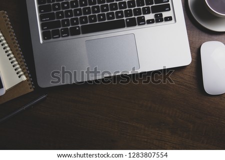 Office desk table with notebook, computer keyboard, mobile phone and other office supplies. Top view with copy space, flat lay. vintage background.