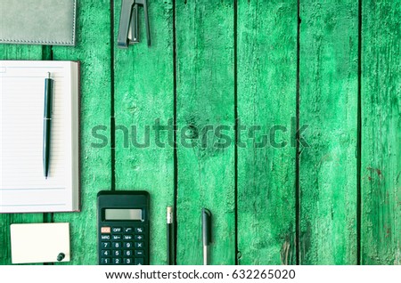 Office desk table with open note book, pen, calculator, wallet, pencil and stapler, . Top view with copy space, flat lay style. Business background.