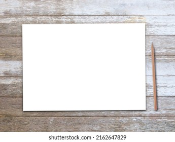 Office desk, white blank paper or notepad with brown pencil on wood table background. Top view with copy space.Concept for business and education design. 