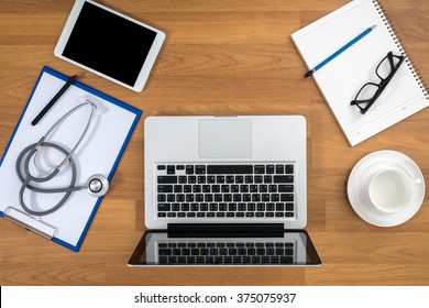 Office Desk And Working On His Laptop With Medical Equipment All Around, Top View