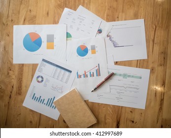 Office Desk Workplace With Pc, Paper Charts Or Graph And Notebook And Pen On Wooden Table. Top View. Release Concept.