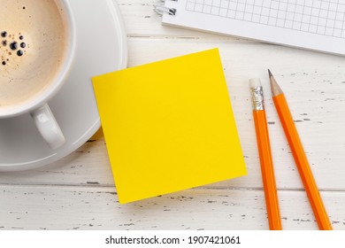 Office desk with yellow sticker, coffee and notepad. Remote office and work from home concept. Top view flat lay with copy space - Powered by Shutterstock