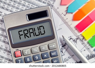 Office Desktop With Calculator Displaying The Word Fraud. Business And Financial Crime Concept.