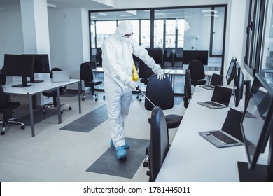 Office disinfection during COVID-19 pandemic. Man in protective suit and face mask spraying for disinfection in the office - Shutterstock ID 1781445011