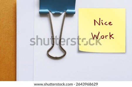 Office document with compliment note NICE WORK  - giving positive feedback in response to job well done - compliment from manager boss to team member employee - praise from teacher to student 