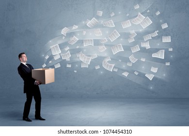 Office documents, contracts, papers flying out of cardboard box being held by a young business worker concept. - Shutterstock ID 1074454310