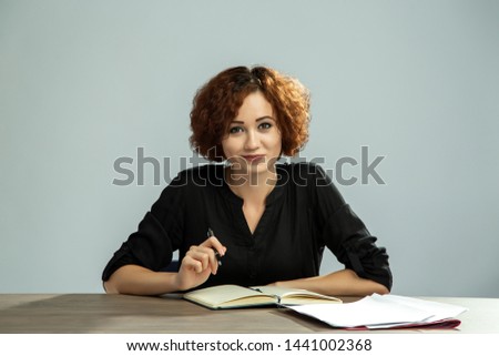 Office employee girl works at a desk with documents