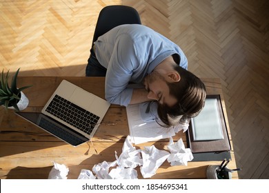 Office Employee Sleeping At Workplace Desk, Above View. Desperate Worker Not Find Solution Or Creative Ideas Got Tired, Fell Asleep, Heap Of Crumpled Papers On Table. Chronic Fatigue Syndrome Concept