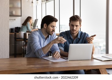 Office employees discussing project at laptop, sharing ideas. Mentor training intern skills, explaining work process. Manager showing presentation to client. Business meeting, internship concept - Shutterstock ID 2022462209