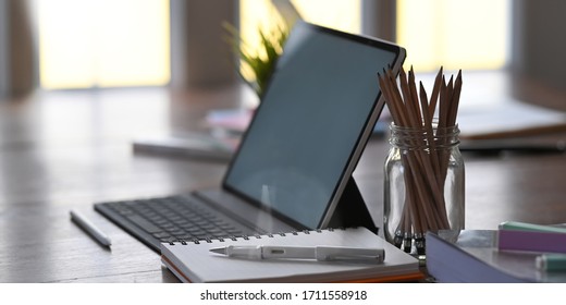 Office equipment on home working desk with tablet, pencil, pen and notebook.