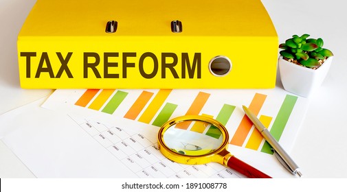 office folder with text TAX REFORM on charts, magnifier and pen