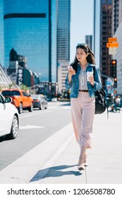 Office Lady Holding Coffee And Cellphone, Walking On The Street To Work. Fresh Graduate Started Working In The City Center In LA. Young Female Worker Lifestyle.