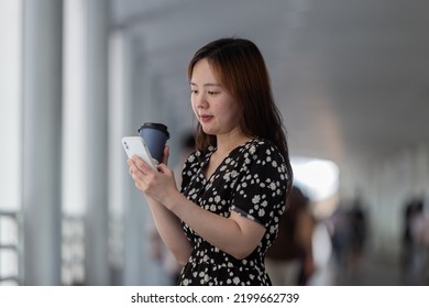 Office Lady Holding Coffee And Cellphone.City On Day Background With Copy Space.