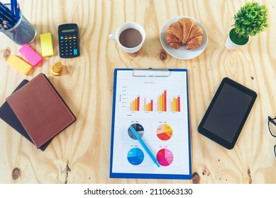 Office Laptop Business Financial Document Chart And Graph On Wooden Table With Coffee Cup. Flat Lay Notebook Computer Laptop On Office Desk. No People Business Graph Chart Mockup On Business Workspace