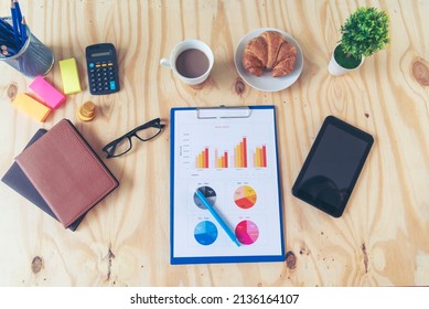 Office Laptop Business Financial Document Chart And Graph On Wooden Table With Coffee Cup. Flat Lay Notebook Computer Laptop On Office Desk. No People Business Graph Chart Mockup On Business Workspace