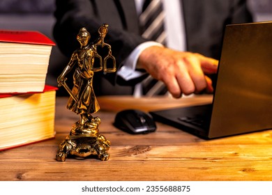 office of a lawyer with books and a statue of Lady Justice, goddess Justitia, on the desk