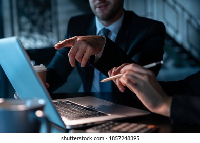 Office Male Manager Pointing Finger At The Laptop Screen At Night. Office Business Colleagues Working With Laptop, No Face, Man And Female Managers In Office With Laptop, Concept Of Work