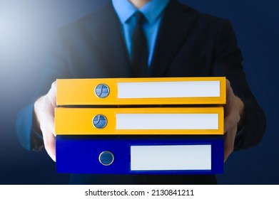 Office man in suit and tie in with stack of ring binders for archiving documents over clean background. File, Ring Binder, Emotional Stress.
