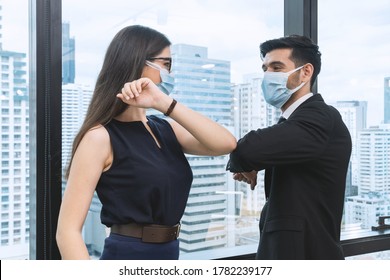 Office Man And Woman Wearing Face Mask Greeting By Elbow Bump.