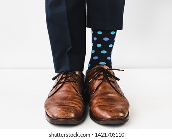 Office manager standing in stylish shoes, blue pants and bright, colorful socks on a white background. Close-up. Studio photo. Concept of lifestyle, fun and elegance - Powered by Shutterstock