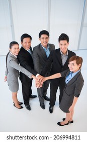 Office managers stacking their hands as a symbol of unity