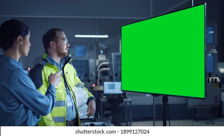 Office Meeting: Confident Female Project Manager to Chief Engineer, Watching Interactive Digital Whiteboard TV that Shows Green Screen Chroma Key Display. Factory with Machinery. - Powered by Shutterstock