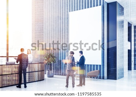 Office reception area with long reception table, gray and black walls, panoramic windows and leather armchairs near neat round coffee tables. Business pepole near vertical mock up poster Toned image