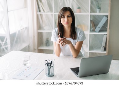 Office Relocation. Real Estate. Property Rent. Confident Female Manager Working Remotely With Laptop Phone In Light Room With Furniture Covered With Transparent Polyethylene Film.