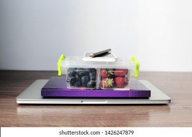 Office Set Up And Healthy Fruits. Lunch Box With Strawberries And Blueberries